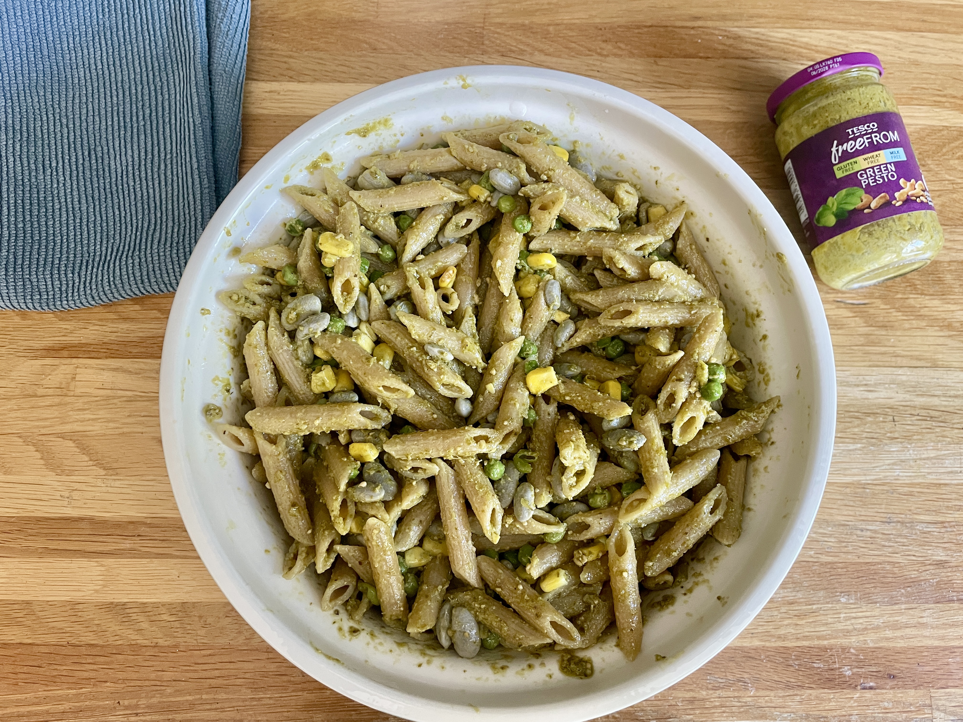 huge sharing bowl of vegan pasta pesto with peas, sweetcorn and purple french beans 